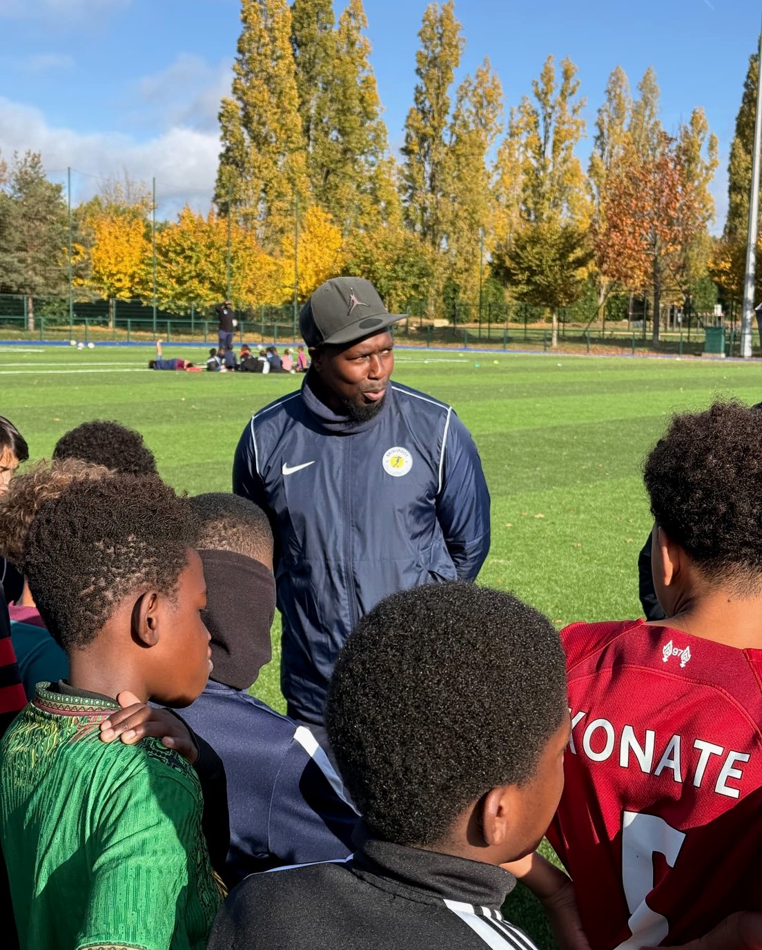 Le coach échange avec un groupe de jeunes joueurs